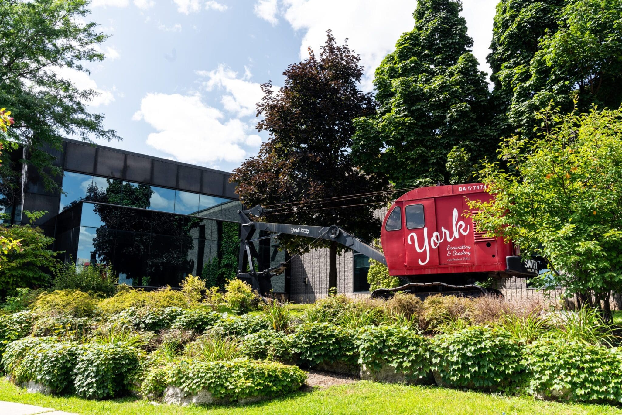 York1 red antique backhoe and garden display in front of corporate office