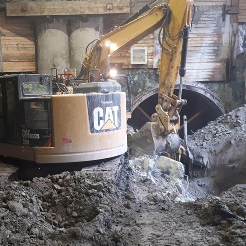 an excavator digging in the dirt for the Peel Tunnel infrastructure project