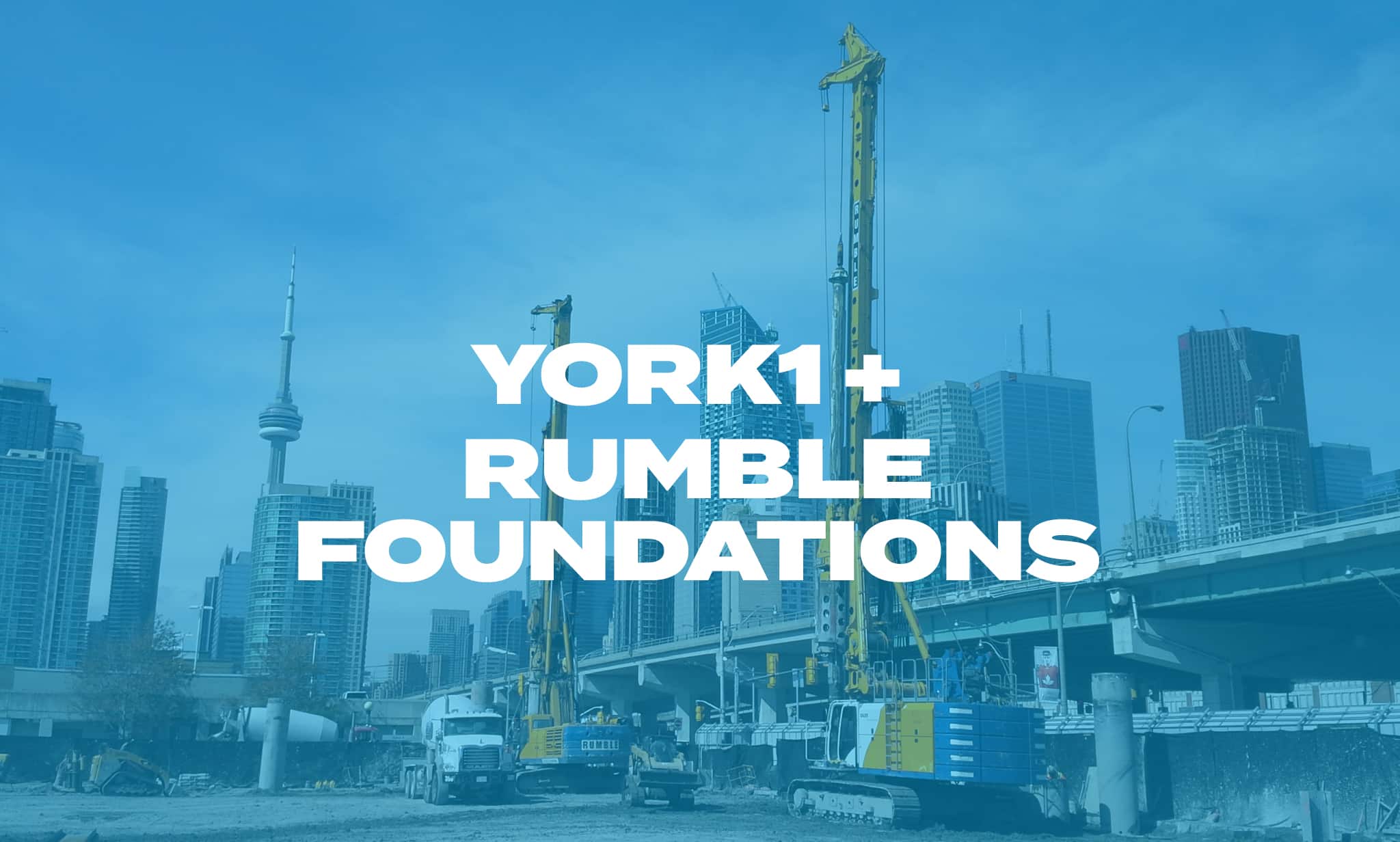 Two hydraulic rigs completing a shoring job with the CN tower and skyscrapers in the background. Photo with blue overlay, York1 + Rumble in white text.