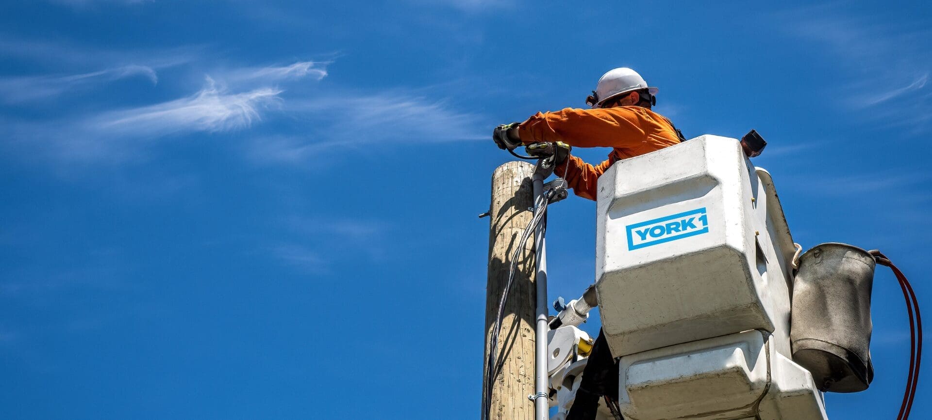 An employee of performing aerial utility work at height