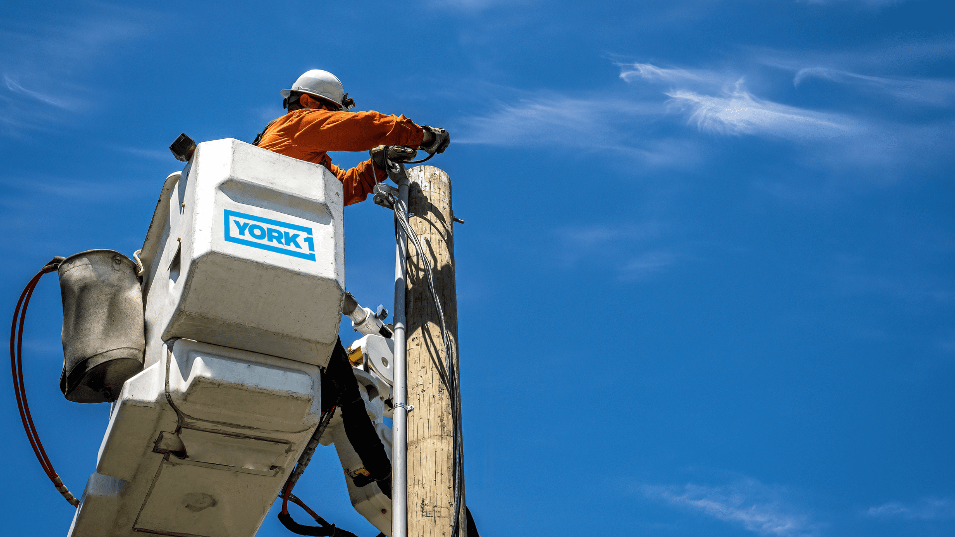 An employee of performing aerial utility work at height