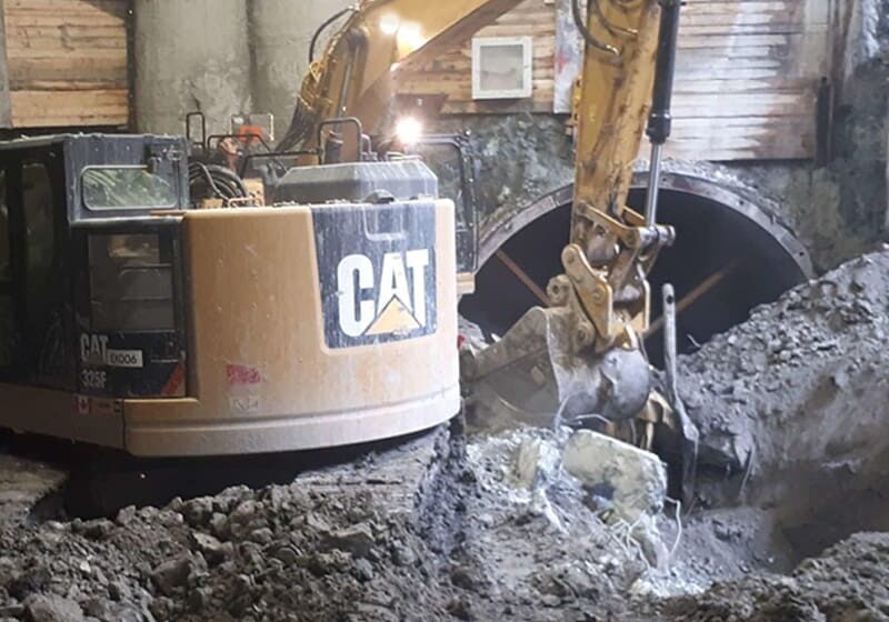 an excavator digging in the dirt for the Peel Tunnel infrastructure project