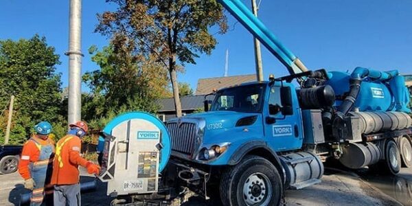 Hydrovac sewer flushing equipment clearing debris from underground pipes.