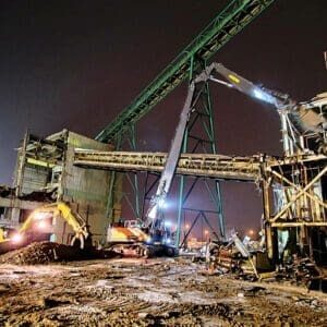 Mine decommissioning project at night, featuring high reach machinery and debris management