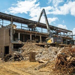 Mill demolition project and metal asset recovery featuring a high reach machine dismantling the top of the mill