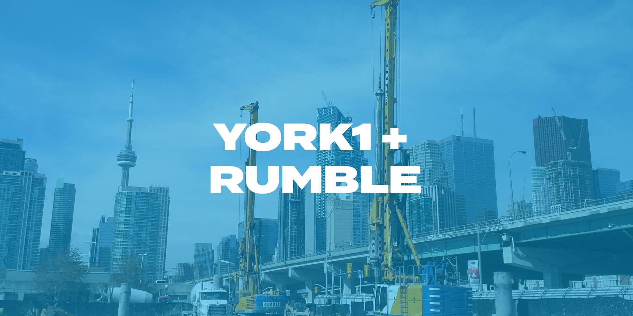 Two hydraulic rigs completing a shoring job with the CN tower and skyscrapers in the background. Photo with blue overlay, York1 + Rumble in white text.