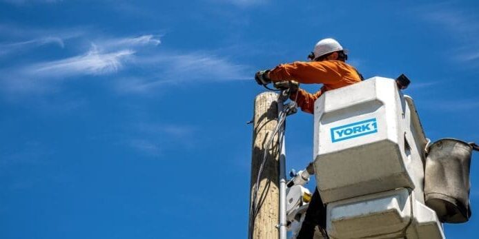 An employee of performing aerial utility work at height